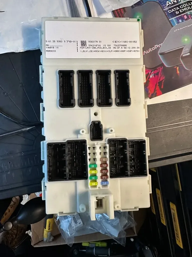 BMW body control module on the bench with its connectors, during a key programming job