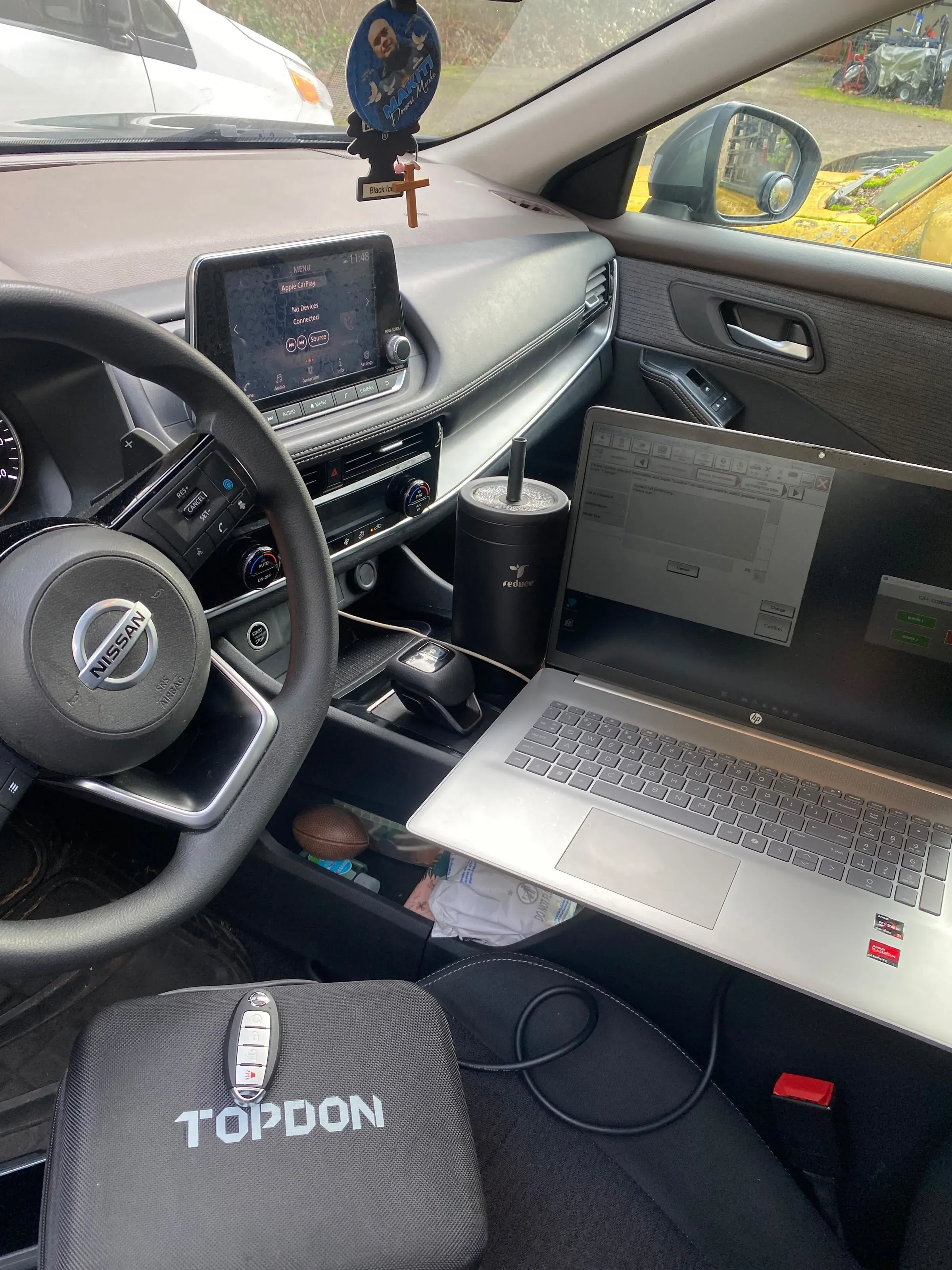 Programming a new Nissan smart key inside the car with a laptop and a diagnostic tool