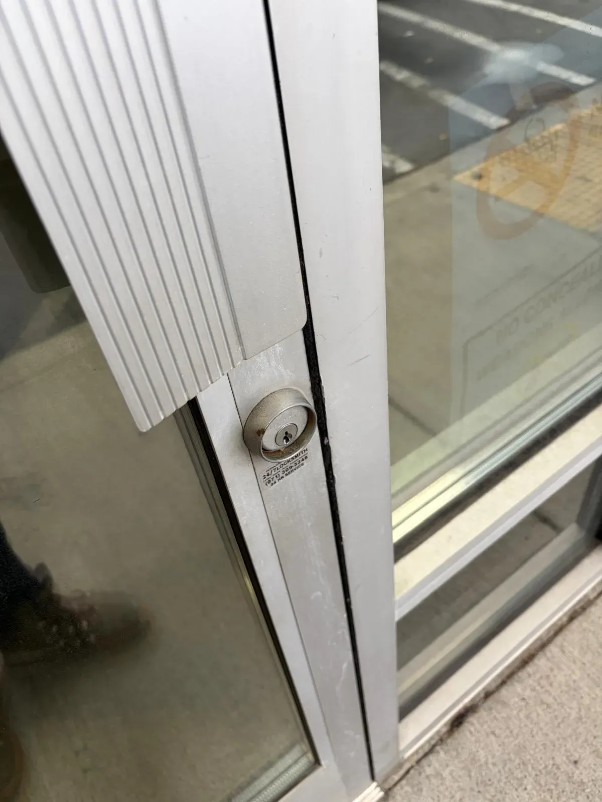 Deadbolt cylinder on the frame of a glass storefront door